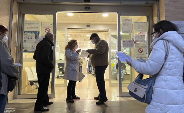 Una sanitaria guía a un paciente a las puertas de un centro de salud. 